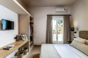 a bedroom with a bed and a tv and a window at Hotel Eucalyptus in Mesaria