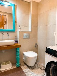 a bathroom with a toilet and a sink and a washing machine at Μπαλκόνι in Nafplio