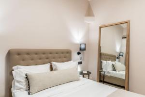 sypialnia z białym łóżkiem i lustrem w obiekcie Hotel Eucalyptus w mieście Mesaria
