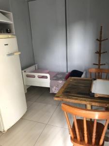 a kitchen with a table and a bed in a room at Residencial Solar Del Nieto in Garopaba