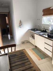 a white kitchen with a sink and a stove at Residencial Solar Del Nieto in Garopaba