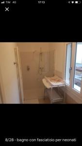 a bathroom with a shower and a table and a window at Center, 15 minutes from Venice, Parking Miranese in Mestre