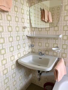 ein Bad mit einem Waschbecken und einem Spiegel in der Unterkunft Garni Rika in Partschins