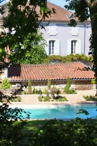 a house with a swimming pool in front of it at La Pêche in Piégut-Pluviers