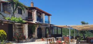 a house with a patio with tables and chairs at Nireas : Stone Villa in Zakynthos