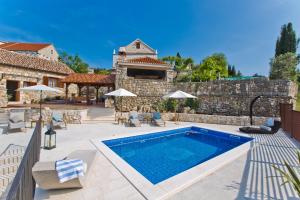 a patio with a swimming pool and a house at Villa Kate -with private pool and BBQ in Brusje