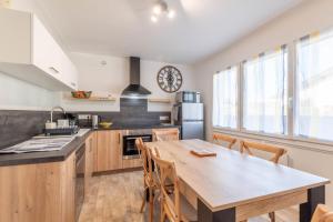 a kitchen with a wooden table and a dining room at Ideally Located Furnished Townhouse With 3 Bedrooms Parking & Garden in Annecy