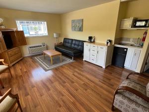 ein Wohnzimmer mit einem schwarzen Ledersofa und einer Küche in der Unterkunft Solvang Inn & Cottages in Solvang