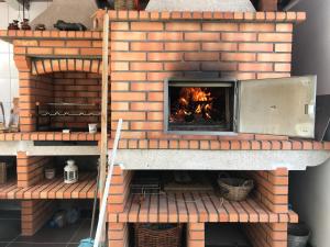 a brick pizza oven with a fire in it at Casa José Lourenço in Folgosa