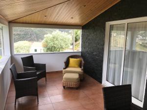 a screened in porch with chairs and a couch at Casa José Lourenço in Folgosa