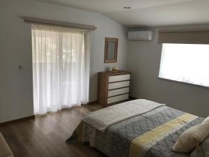 a bedroom with a bed and a window and a dresser at Casa José Lourenço in Folgosa