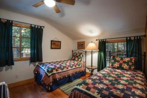 a bedroom with two beds and a ceiling fan at Bassett's Cabin in Wawona