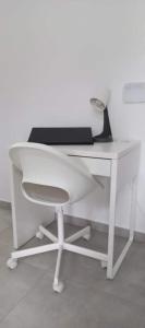 a white desk with a laptop and a chair at Nama Villa 250m from the sea in Makry Gialos