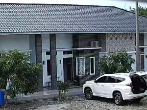 um carro branco estacionado em frente a uma casa em Cahaya kos putri em Banda Aceh