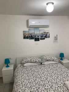 ein Schlafzimmer mit einem Bett und zwei Lampen und Bildern an der Wand in der Unterkunft center Mestre 15 minutes from Venice, parking Bellini in Mestre