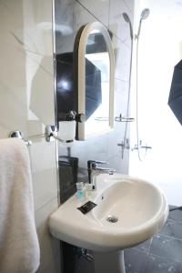 a bathroom with a white sink and a mirror at Quiet Rooms Suites 6 By Quiet Rooms in Riyadh +25 photos