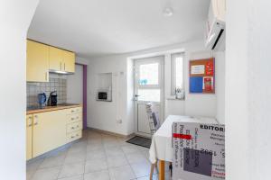 a kitchen with white cabinets and a table in a room at Ivica in Hvar