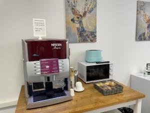 een koffiezetapparaat en een magnetron op een tafel bij Hotel Boutique Centro BBB Auto check in in Benidorm