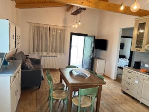 cocina y sala de estar con mesa y sillas en Agriturismo Quartuccio en Oricola
