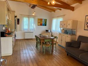 a kitchen and living room with a table and a couch at Agriturismo Quartuccio in Oricola