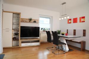 a living room with a dining table and a television at Ferienwohnung Gipfelglück in Oberammergau