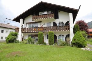 a house with a balcony on top of a yard at Ferienwohnung Gipfelglück in Oberammergau
