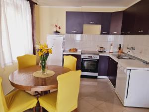 cocina con mesa de madera y sillas amarillas en Apartment Sanja, en Pazin