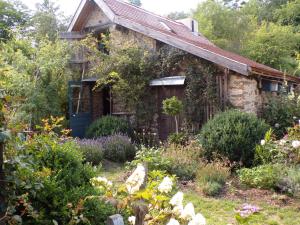 an old stone house with a garden in front of it at la maison de Royer in Meuzac