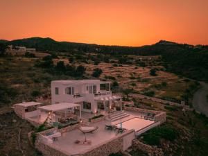 a white house with a sunset in the background at Avgi holiday villa in Agios Nikolaos