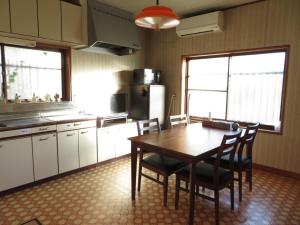 uma cozinha com uma mesa e cadeiras numa cozinha em Lu Blue Sado SAWANE - Vacation STAY 12885 em Sado
