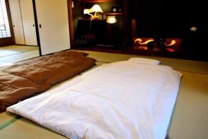 un letto bianco sul pavimento in una stanza di Minpaku Yorozuya - Vacation STAY 12905 a Kurayoshi