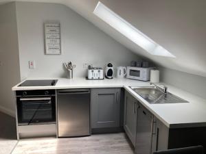 uma cozinha branca com um lavatório e um fogão em Lir Lodge em Castlepollard