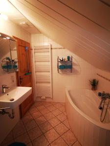 a bathroom with a white tub and a sink at Ferienwohnung auf dem Fischer-Hof in Stolpen
