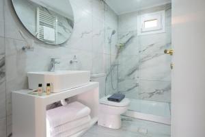 a bathroom with a sink and a toilet and a mirror at Centrale Lefkada old town in Lefkada Town +29 photos