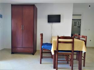 a dining room with a table and chairs and a cabinet at Ahmeti Rooms in Ksamil
