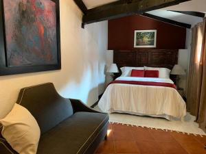a bedroom with a bed and a couch in a room at Casa del Manchén in Antigua Guatemala