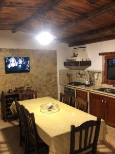 a kitchen with a table and a tv on the wall at Il casale degli aragonesi in Reggio di Calabria