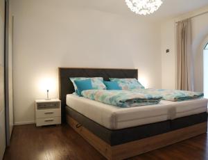 a bedroom with a bed with blue pillows and a night stand at Ferienwohnung Gipfelglück in Oberammergau