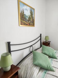- une chambre avec un lit et 2 oreillers verts dans l'établissement Il Giardino degli Ulivi, à Citta' Sant'Angelo