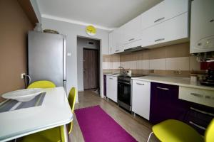 a kitchen with white cabinets and a table and chairs at Oasis House in Hunedoara