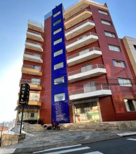 um edifício de apartamentos alto com uma fachada colorida em Tropical Palace Hotel em Lavras