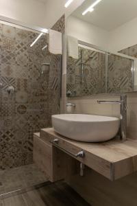 ein Badezimmer mit einem Waschbecken, einem Spiegel und einer Badewanne in der Unterkunft B&B Maremy... I 4 Elementi in Neapel