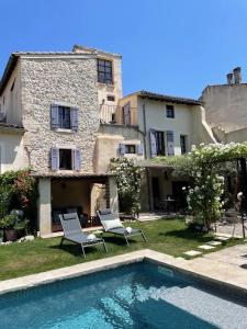 une maison avec une piscine en face d'un bâtiment dans l'établissement B&B Temps Suspendu Provence, à Pernes-les-Fontaines