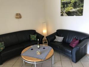 a living room with two black couches and a table at Holiday home in Olsdorf in Bettingen