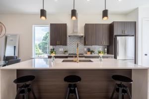 a kitchen with a sink and two bar stools at Downtown ATL Modern Home - Private Rooftop Terrace in Atlanta