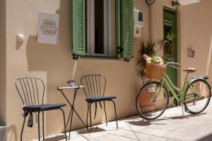 a bike parked on the side of a building with two chairs at Centrale Lefkada old town in Lefkada Town