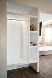 um quarto com uma cama e uma parede branca em LP Luxury Suite - Old Town Xanthi em Xanthi