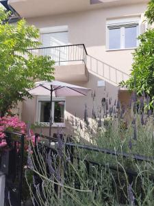 una casa con un ombrello e dei fiori di Mary's Dreamy Maisonette a Volos