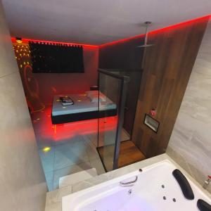 uma casa de banho com banheira e uma cama num quarto em Desejo Motel em Araçoiaba da Serra