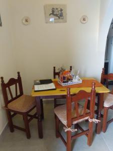 einem Esstisch mit 2 Stühlen und einem Tisch mit einem Laptop in der Unterkunft Departamento Termas de Río Hondo in Termas de Río Hondo